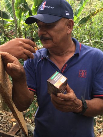A farmer smelling the turmeric in Gaia's Turmeric Supreme® formula made with turmeric he grows.